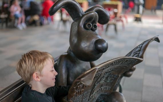 Boy reading over Gromit's shoulder