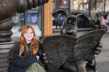 Child having selfie on Wallace and Gromit bench