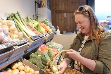 Woman filling basket with vegetables at Fresh and Fruity