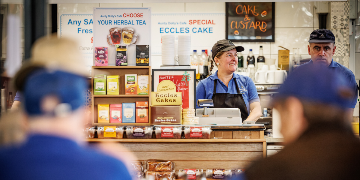 Trader smiling behind counter at Aunt Dollys