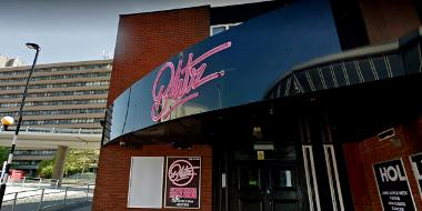 Entrance to Blitz music venue in Preston, with retro pink neon sign above door.