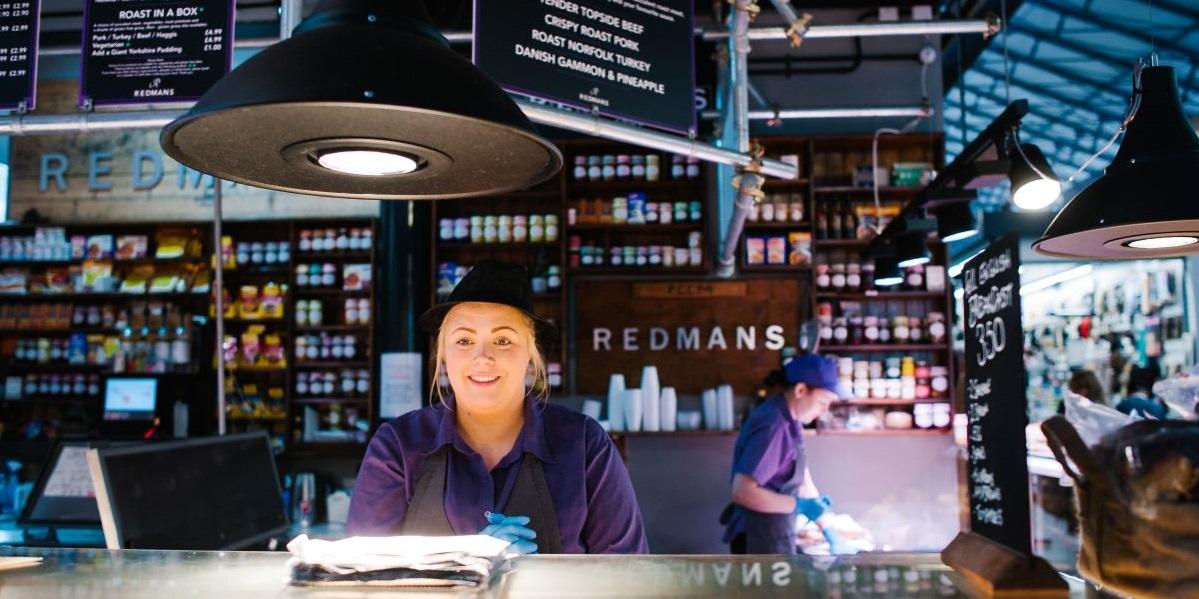 Trader behind counter at Redman's, in Preston Market Hall Trader behind counter at Redman's, in Preston Market Hall